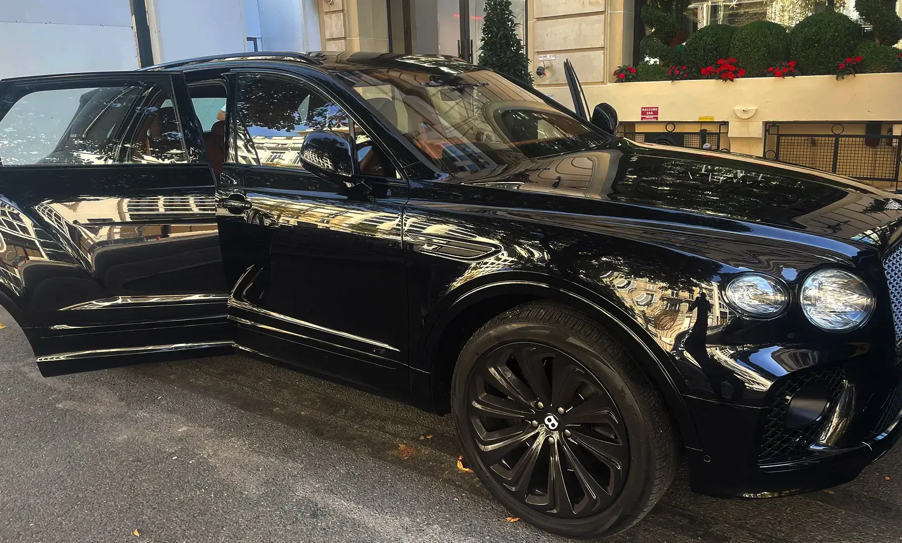 Lavage complet d'une Bentley noire devan un hôtel parisien.