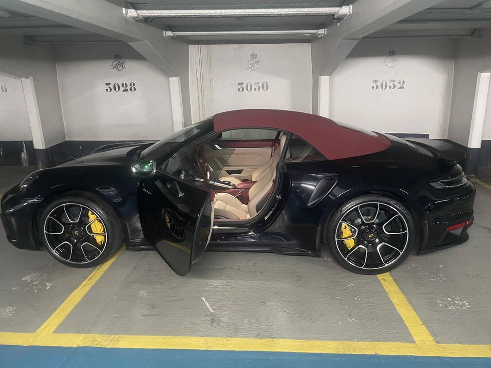 Une Porsche noire juste après nettoyage dans un parking souterrain.